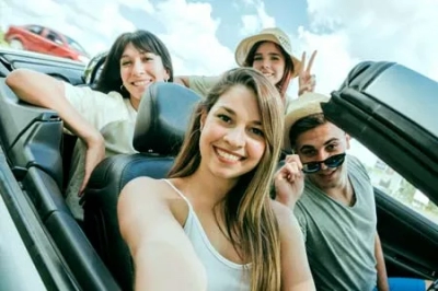 Group of young friends on a road trip in a convertible car – fun summer travel experience with Ghoom Bindaas Holidays